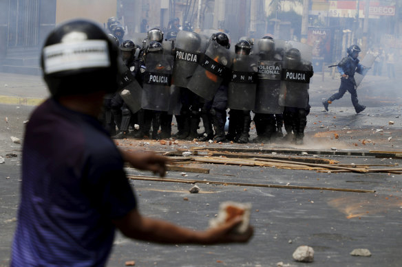 A demostrator prepares to hurl a rock at police during a protest in Honduras.