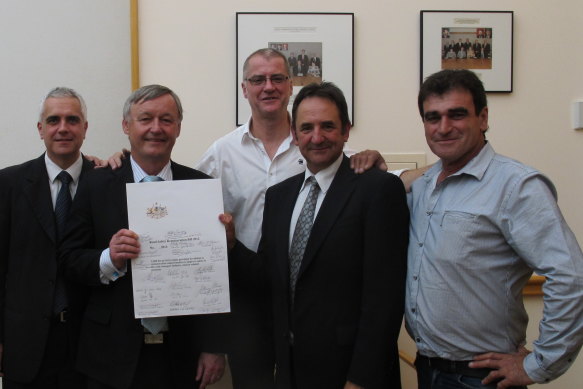 Senator Alex Gallacher holding the Road Safety Remuneration Bill 2012 he fought for. Pictured with (from left) TWU officials Michael Kaine and Tony Sheldon, senator Glenn Sterle and truck driver Frank Black. 