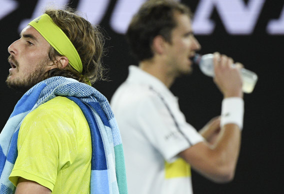 Stefanos Tsitsipas walks past Daniil Medvedev during their Australian Open semi-final clash last year.