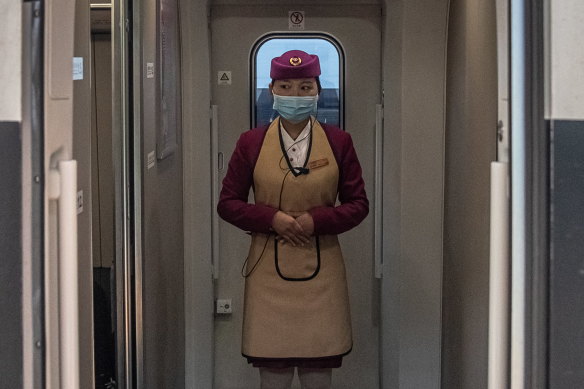 A train attendant stands on a train to Wuhan, the epicentre of the global outbreak, at a railway station in Beijing on Sunday.