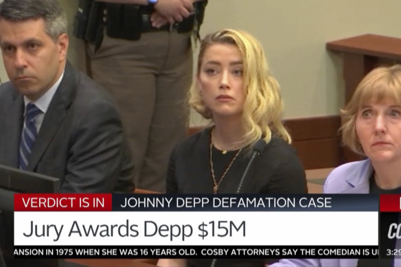 Amber Heard, centre, and her lawyers react as the verdict is read.