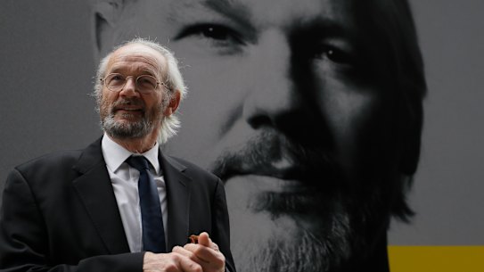 Julian Assange’s biological father John Shipton stands in front of his poster near the Central Criminal Court Old Bailey in London.