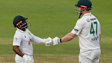 South Africa’s captain Temba Bavuma, left, pumps his fists with Simon Harmer.
