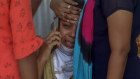 Relatives of a person who died of COVID-19 mourn outside a field hospital in Mumbai, India.