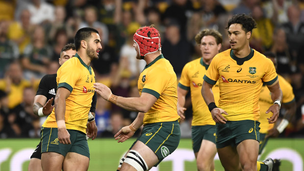Wallabies teammates congratulate Tom Wright after his early try on debut.