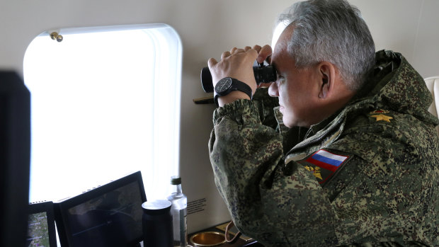 Russian Defense Minister Sergei Shoigu watches drills form a board of military helicopter in Crimea. 