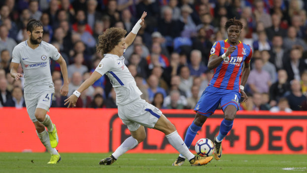 On the charge: Wilfried Zaha tries to beat David Luiz of Chelsea.