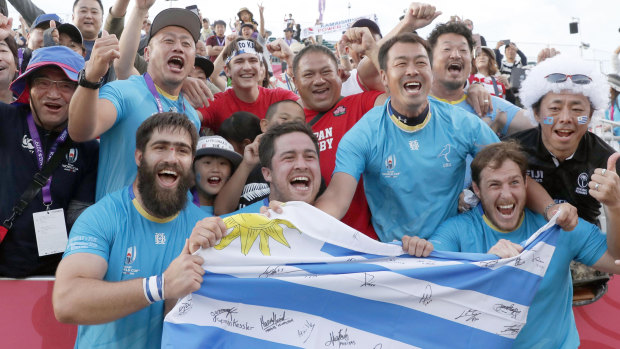 Triumphant Uruguayan players celebrate with the crowd after their stunning defeat of Fiji in the World Cup.