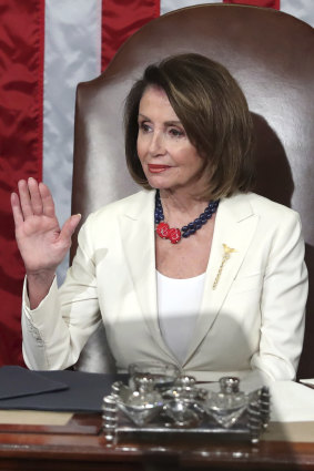 Nancy Pelosi raises her hand in a gesture to quiet the Democrats.