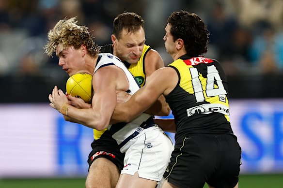 Tanner Bruhn of the Cats is tackled by Toby Nankervis (left) and Tim Taranto of the Tigers.