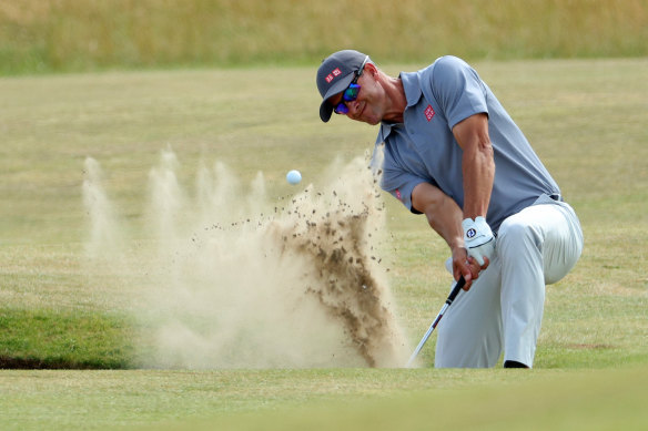 Adam Scott plays out of a bunker on the 4th hole.
