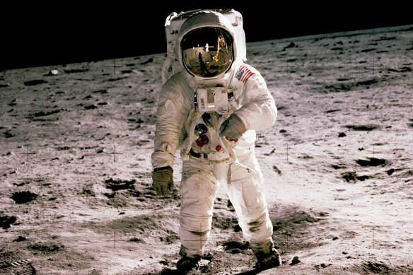 Buzz Aldrin walks on the moon during the first human landing in 1969. Fellow astronaut, Neil Armstrong, the first to set foot on the moon, is seen reflected in Aldrin’s helmet glass.