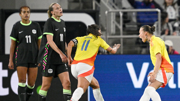 Colombian captain Catalina Usme celebrates her goal in front of Emily Van Egmond and Mary Fowler.
