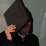 Tobacco tycoon Muh’d Alzoubi hid his face behind an ipad as he left Downing Centre Local Court on Friday.