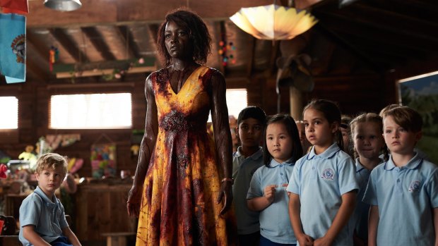 Lupita Nyong'o as Miss Caroline with her kindergarten class in Little Monsters.