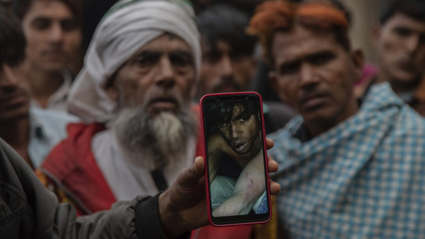 A man holds a phone in January this year showing a video of Muslim farmer moments after being beaten for allegedly smuggling cows in Mirzapur, India.