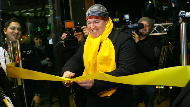 The first man to receive an iPhone 3G cuts the ribbon to the store.