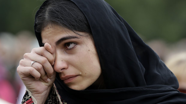 A woman wipes away tears during a gathering for the 'March for Love' in Hagley Park, Christchurch.