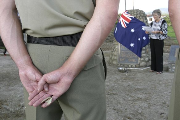 An Australian army officer from the 16th Air Defence Regiment holds a gum leaf in his hand, which is then burnt as a symbolic act, at the service of remembrance at the POW camp site at Ranau. Pictured is Lynette Silver.