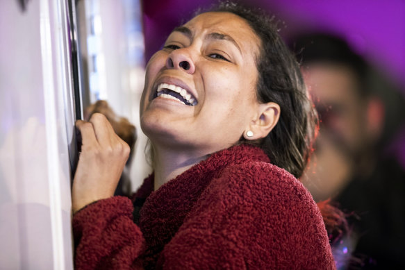 A migrant leans against an ambulance as a person she knows is attended by medics after a fire broke out at the Mexican Immigration Detention centre in Juarez.