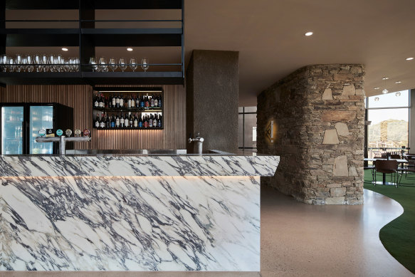 Instead of the usual plaid carpet, there’s a turf-like green carpeted floor in the members’ lounge that appears to seamlessly connect to the manicured lawns