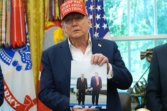 Trump displays an image of himself with Putin last week, and said the Russian leader had expressed the desire to attend the soccer World Cup in the US next year.