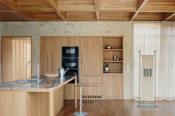 The kitchen shows a sense of restraint and consideration, with its bagged brick walls, timber joinery and stone benches.