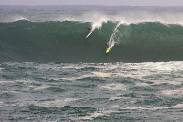 Jamie Mitchell, right, and Ross Clarke-Jones take on Waimea Bay during the last Eddie Aikau Invitational in 2016.