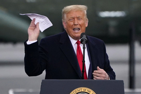 Donald Trump holds a piece of paper during an election rally in 2000. Insiders say he repeatedly tore up documents during his presidential term, in breach of preservation laws. 