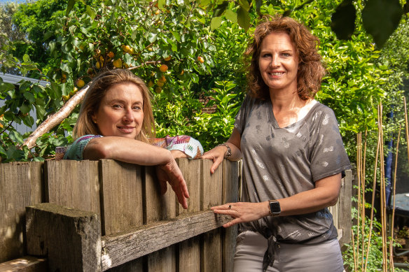 Belinda Jackson (left) and Jude van Daalen by the garden fence where they had meetings during the creation of their book about life under COVID-19 restrictions.