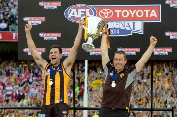 Once were warriors: Luke Hodge and Alastair Clarkson lift the 2014 premiership cup.