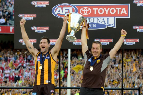 Luke Hodge and Alastair Clarkson lift the 2014 premiership cup.