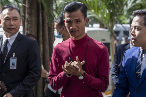 Pro-democracy activist Panupong Jadnok (centre) arrives at a Bangkok court for a hearing to determine whether he had violated his bail conditions.