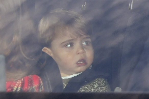 Prince Louis sits in the back of a car driven by his mother.