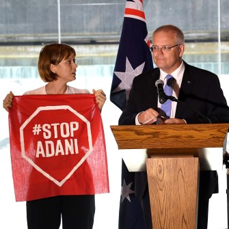 A Stop Adani protestor takes to the stage with Prime Minister Scott Morrison during the campaign.