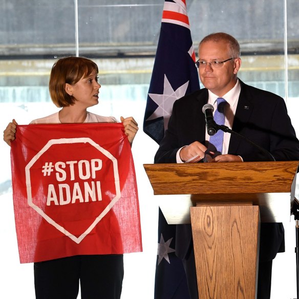 A Stop Adani protestor takes to the stage with Prime Minister Scott Morrison during the campaign.