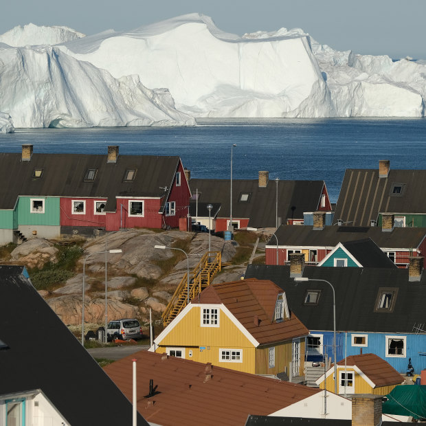 The town of Ilulissat with icebergs looming at the mouth of its fjord in July.