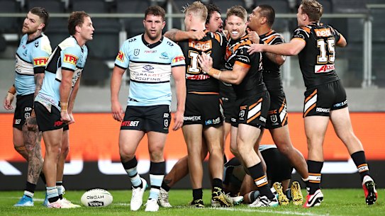 Josh Aloiai of the Wests Tigers celebrates scoring a try.