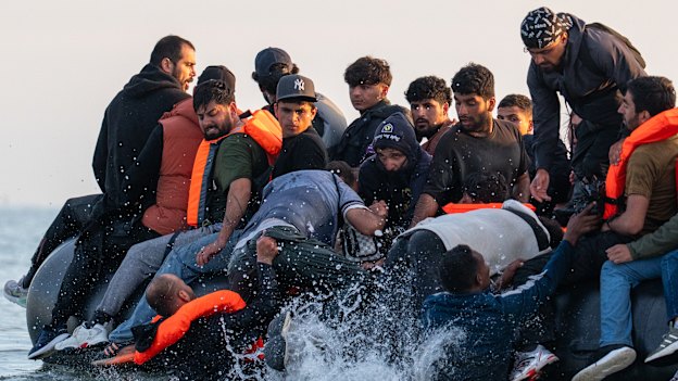 Migrants board a small boat bound for the UK off the shoreline of Gravelines beach in Calais, France on July 17.