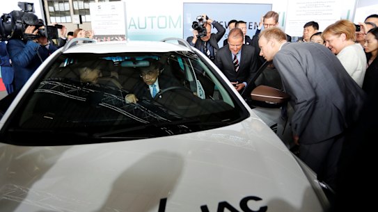Chinese Prime Minister Li Keqiang sits in a car as he and German Chancellor Angela Merkel and Herbert Diess, Volkswagen's CEO, attend a presentation for autonomous driving at Tempelhof airport in Berlin in 2018.