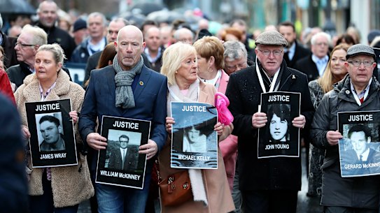 Families hold photographs of the victims of Bloody Sunday and march through the Bogside in Londonderry on Thursday.