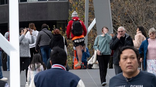 An e-scooter rider weaves through pedestrians on the Evan Walker Bridge in Southbank on Thursday.