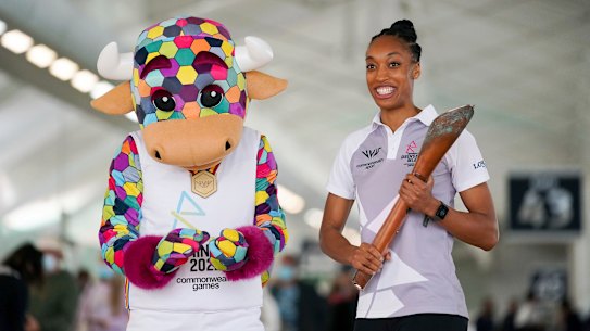 England netballer Layla Guscoth holds the Commonwealth Games baton alongside Perry, the mascot for the Birmingham Games.