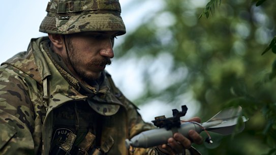 A Ukrainian soldier loads a bomb on a drone near Bakhmut, the site of fierce battles with Russian forces in the Donetsk region on Sunday.