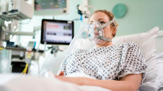 A volunteer demonstrates the use of a CPAP device at University College London Hospital.