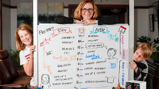 Graphic recorder Debbie Wood with the whiteboard timetable she's set up with sons Toby, 13, and Artie, 9.