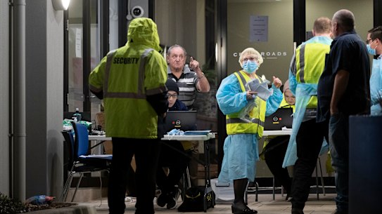 People get checked for coronavirus outside the Crossroads Hotel at Casula on Friday night.