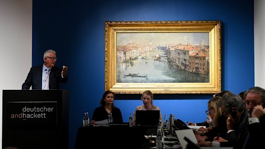 Auctioneer Roger McIlroy with Arthur Streeton’s painting The Grand Canal, 1908, auctioned at Deutscher and Hackett in Melbourne.  