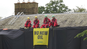 Greenpeace activists sit on the roof of Britain’s Prime Minister Rishi Sunak’s house in Richmond, North Yorkshire, England, after covering it in black fabric on Thursday.