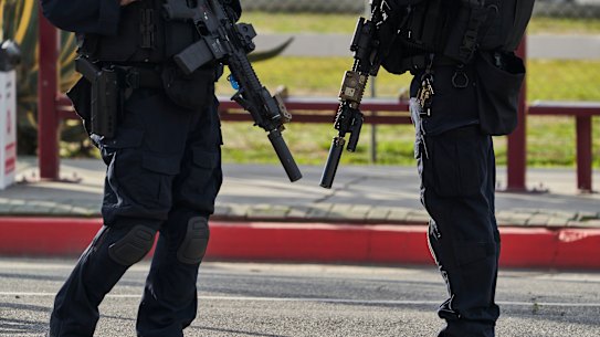 Police officers stand near the Star Dance Studio where a gunman killed 10 people and injured another 10 in Monterey Park